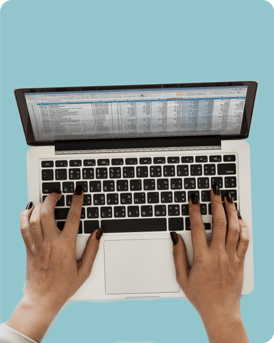 Hands typing on a laptop tracking cryptocurrency