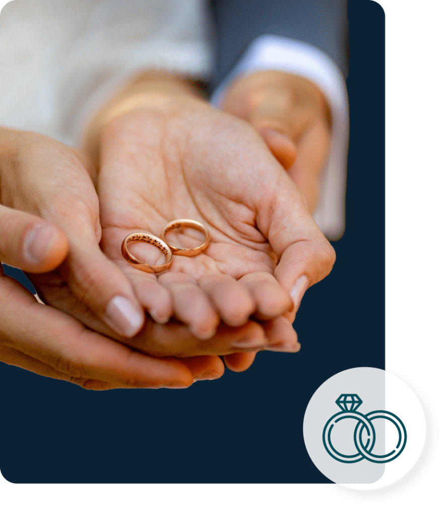 A couple holding 2 rings withing both of their hands together