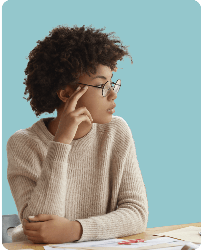 Younger woman with glasses looking off screen concerned